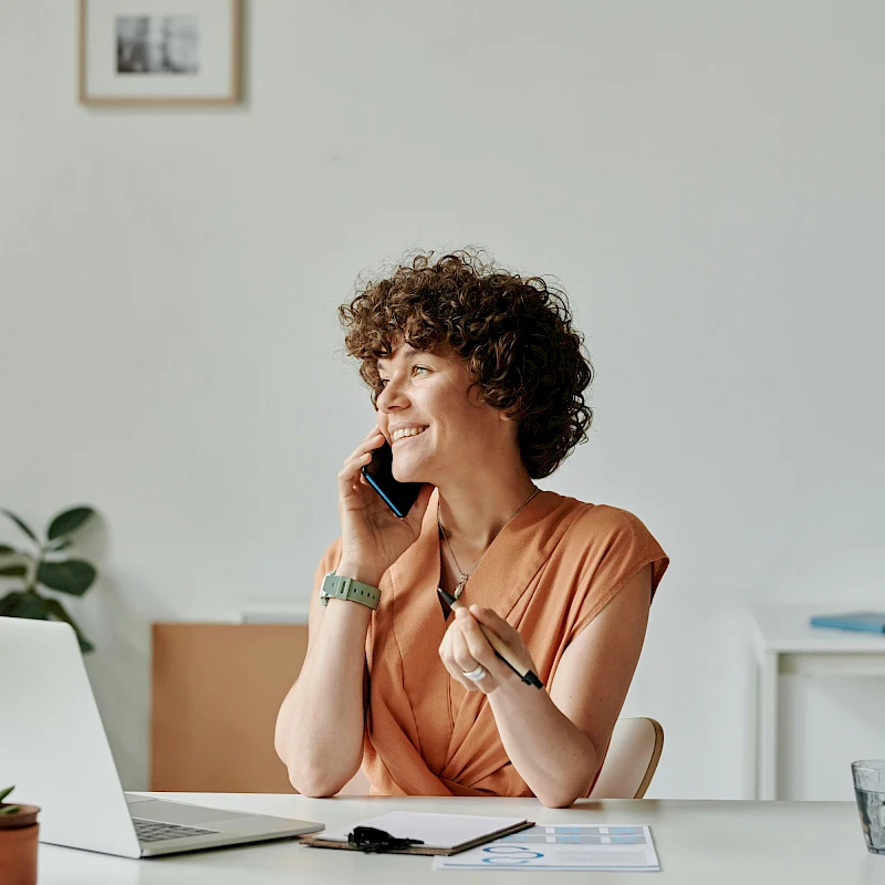 Nő telefonál az irodában