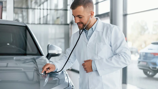Orvos személyautót vizsgál sztetoszkóppal