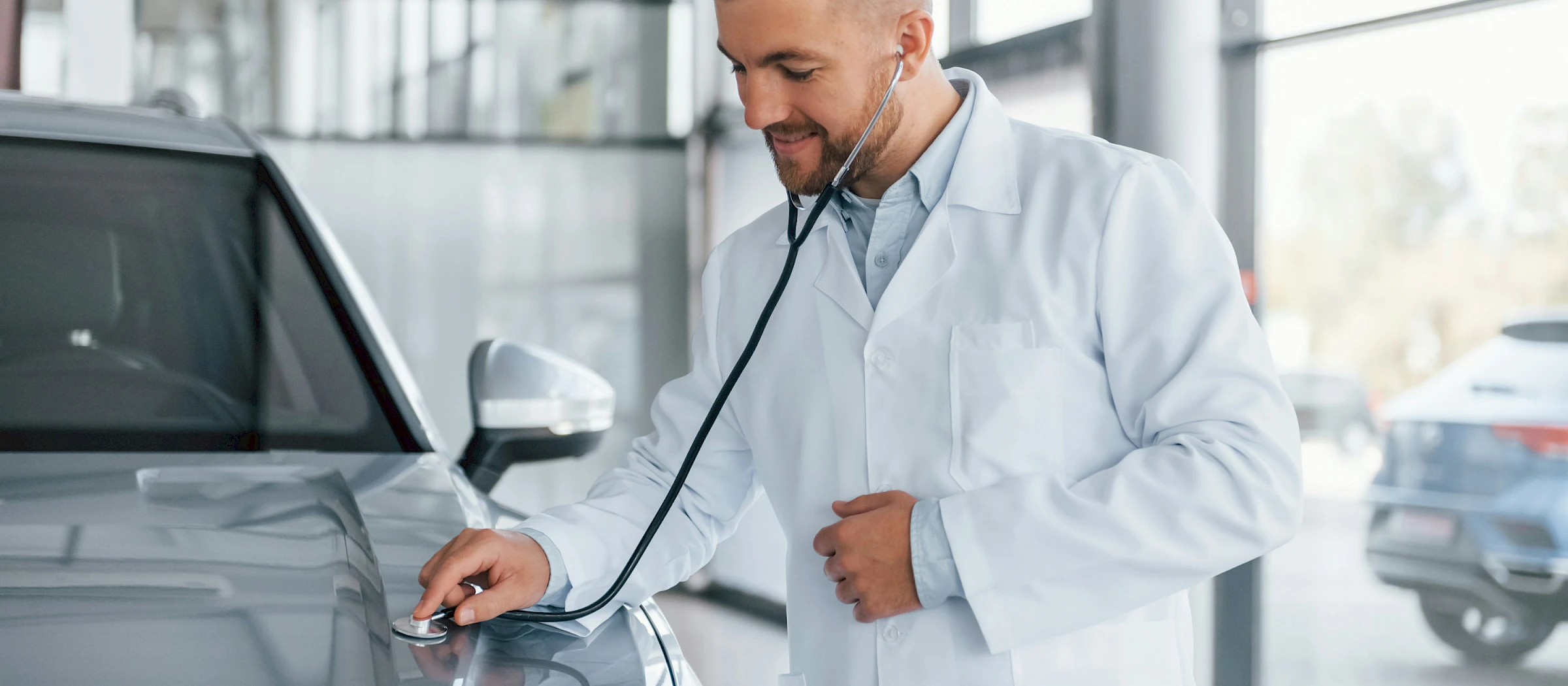 Orvos személyautót vizsgál sztetoszkóppal